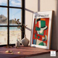 Matisse Art Prints - Abstract Figure with Hat Poster displayed on a wooden table near a window with beach view.