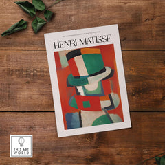 Matisse Art Prints - Abstract Figure with Hat Poster displayed on wood table with green leaves.