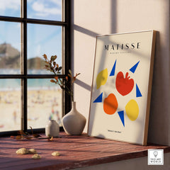 Matisse Art Prints - Abstract Fruit Shapes Blue Triangles Poster displayed in a sunlit room with coastal view.