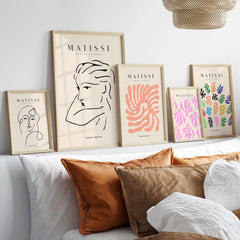 Matisse Art Prints - Abstract Line Drawing of Lady displayed in stylish frames on a shelf above cozy cushions.