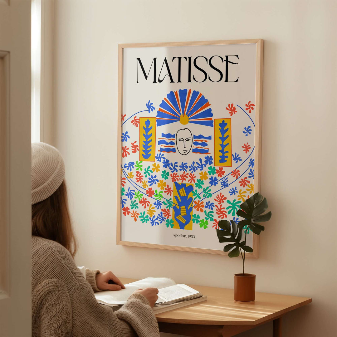Person sitting at a table admiring the Matisse Apollon 1953 decorative wall art print framed on the wall.