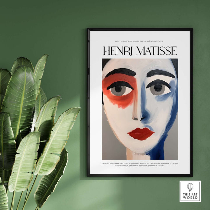 Matisse abstract face portrait print with bold colors displayed on a green wall, surrounded by tropical leaves.