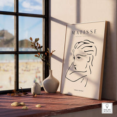 Matisse Art Prints - Abstract Line Drawing of Lady displayed on a sunlit table with scenic seaside view.