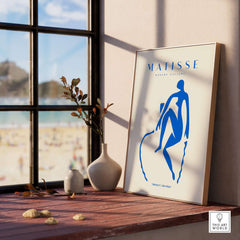 Matisse Art Prints -  Blue Nude Seated Figure Poster displayed in a sunlit room with a beach view.
