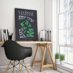 Matisse Art Print Composition Black Green White Abstract Poster 1947 displayed in a modern workspace with chair and plants.