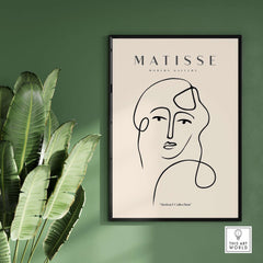 Matisse Art Prints - Continuous Line Abstract Face Poster displayed in a modern gallery setting with greenery.