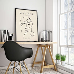 Matisse Art Prints - Continuous Line Abstract Face Poster displayed in a modern workspace with a stylish chair and decor.