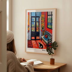 Matisse Art Prints - Interior with Cat and Open Door Poster displayed on a wall with a person reading nearby.