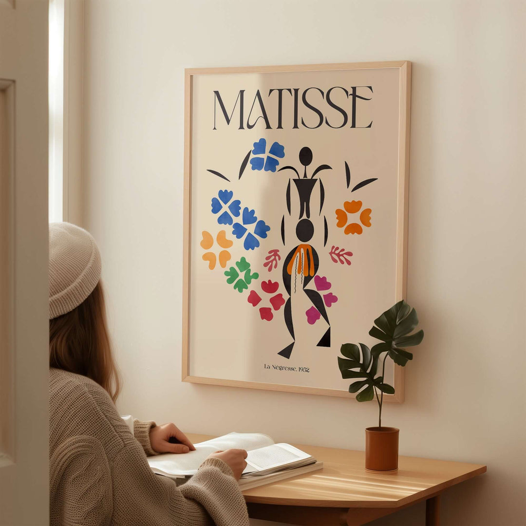 Matisse La Négresse 1952 poster featuring vibrant cut-out floral shapes, displayed in a cozy interior setting.