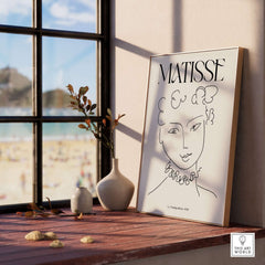 Matisse Art Print La Pompadour 1951 Minimalist Line Drawing Poster displayed in a sunlit room by a window.