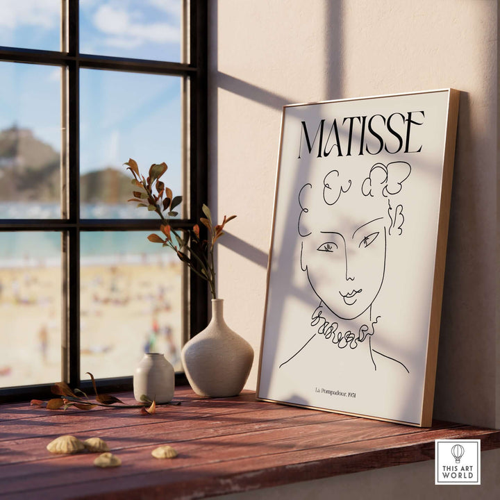 Matisse La Pompadour 1951 minimalist line drawing poster displayed in a sunlit room with beach view.