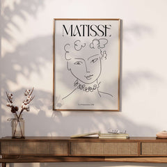 Matisse Art Print La Pompadour 1951 Minimalist Line Drawing Poster displayed in a stylish interior with a wooden console.