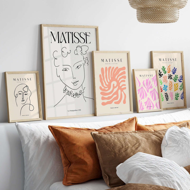Matisse La Pompadour 1951 minimalist line drawing art prints displayed on a wall above decorative pillows.