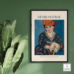Matisse Art Print - Madras Rouge Red Headdress 1907 Wall Art Poster displayed against a green wall, featuring vibrant colors.