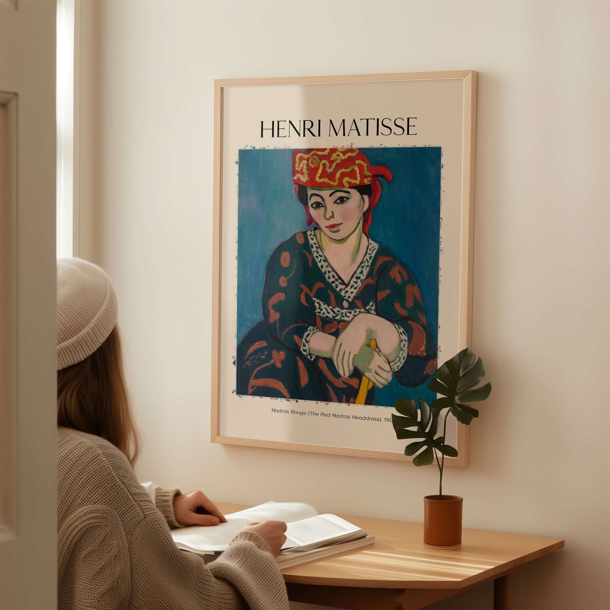 Matisse Art Print - Madras Rouge Red Headdress 1907 Wall Art Poster displayed on a wall with a person reading.
