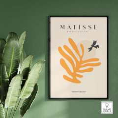 Matisse Art Prints - Orange Leaf Bird Silhouette Poster displayed on a green wall with a plant.