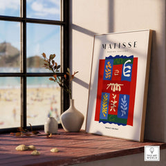Matisse Art Prints - Patchwork Shapes Composition Poster displayed on a shelf with beach view in the background.