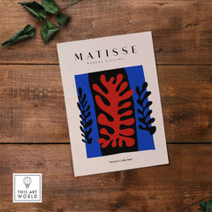 Matisse Art Prints -  Red Coral Black Leaves Blue Frame Poster on a wooden background with leaves.
