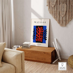 Matisse Art Prints -  Red Coral Black Leaves Blue Frame Poster displayed in cozy living room decor.