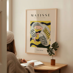 Matisse Art Prints - Resting Woman Patterned Blouse Yellow artwork on wall, with a woman reading at a desk.
