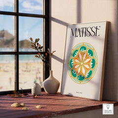 Matisse Art Print Rosace 1954 Rose Window Geometric Art Print displayed on a wooden table by a window.