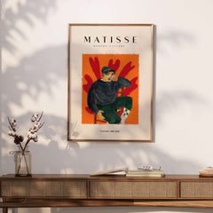 Matisse Art Prints - Seated Figure in Cap Poster featuring a young person seated against a vibrant orange background.
