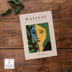 Matisse Art Prints - Split Face Blue Yellow Portrait Poster displayed on wooden background with leaves.