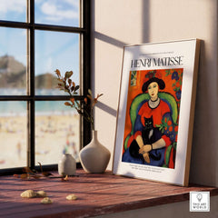 Matisse Art Prints - Woman with Black Cat Interior Poster displayed on a window sill with beach view.
