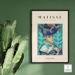 Matisse Art Prints - Woman Large Hat Portrait Teal Background Poster in a modern gallery setting with greenery.