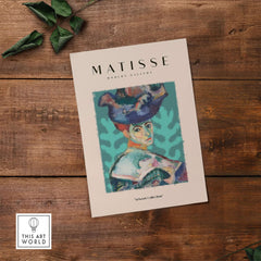Matisse Art Prints - Woman Large Hat Portrait Teal Background Poster displayed in a modern gallery setting.