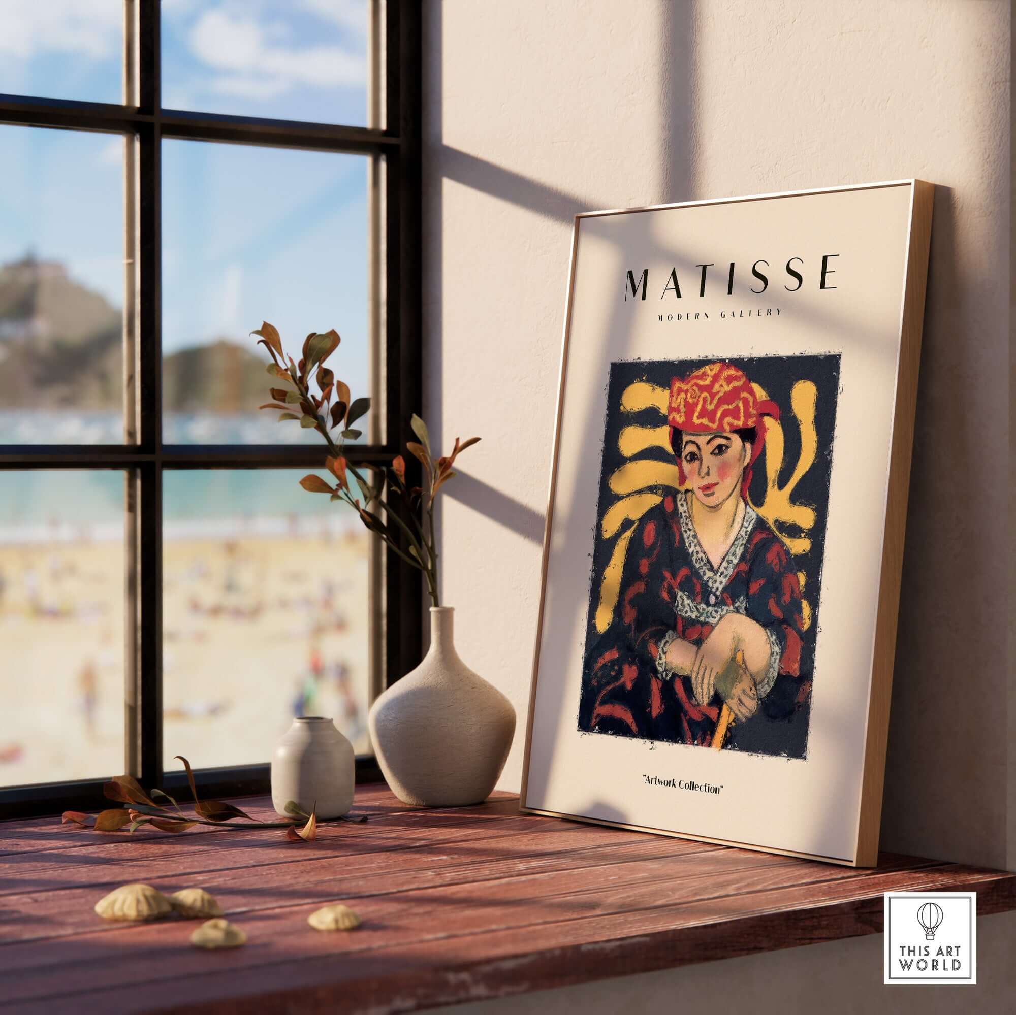 Matisse Art Prints -  Woman in Patterned Hat & Dress Poster displayed on a table near a window with a beach view.