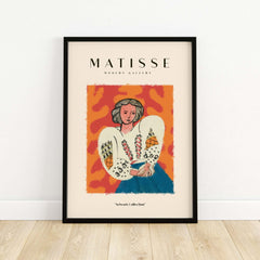 Matisse Art Prints - Woman White Blouse Blue Skirt Portrait Poster in a framed display on a wooden floor.