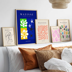 Matisse Art Prints - Abstract Blue Poster displayed among other colorful art prints and framed designs on a stylish wall.