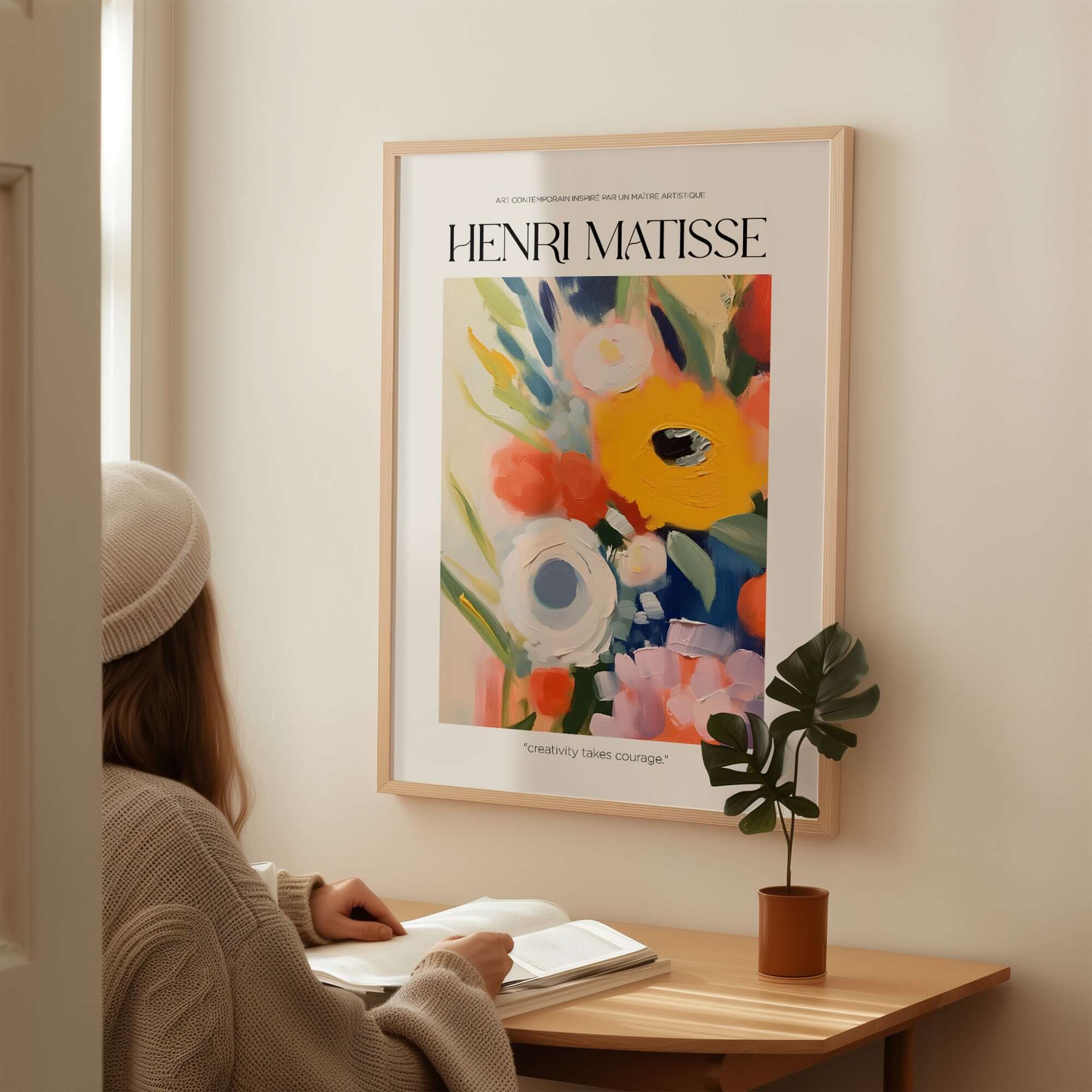 Matisse Art Prints - Abstract Flowers Poster displayed on a wall, with a person reading nearby, showcasing vibrant floral colors.