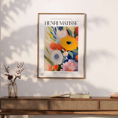 Matisse Art Prints - Abstract Flowers Poster showcasing vibrant floral art in a gold frame on a textured wall.