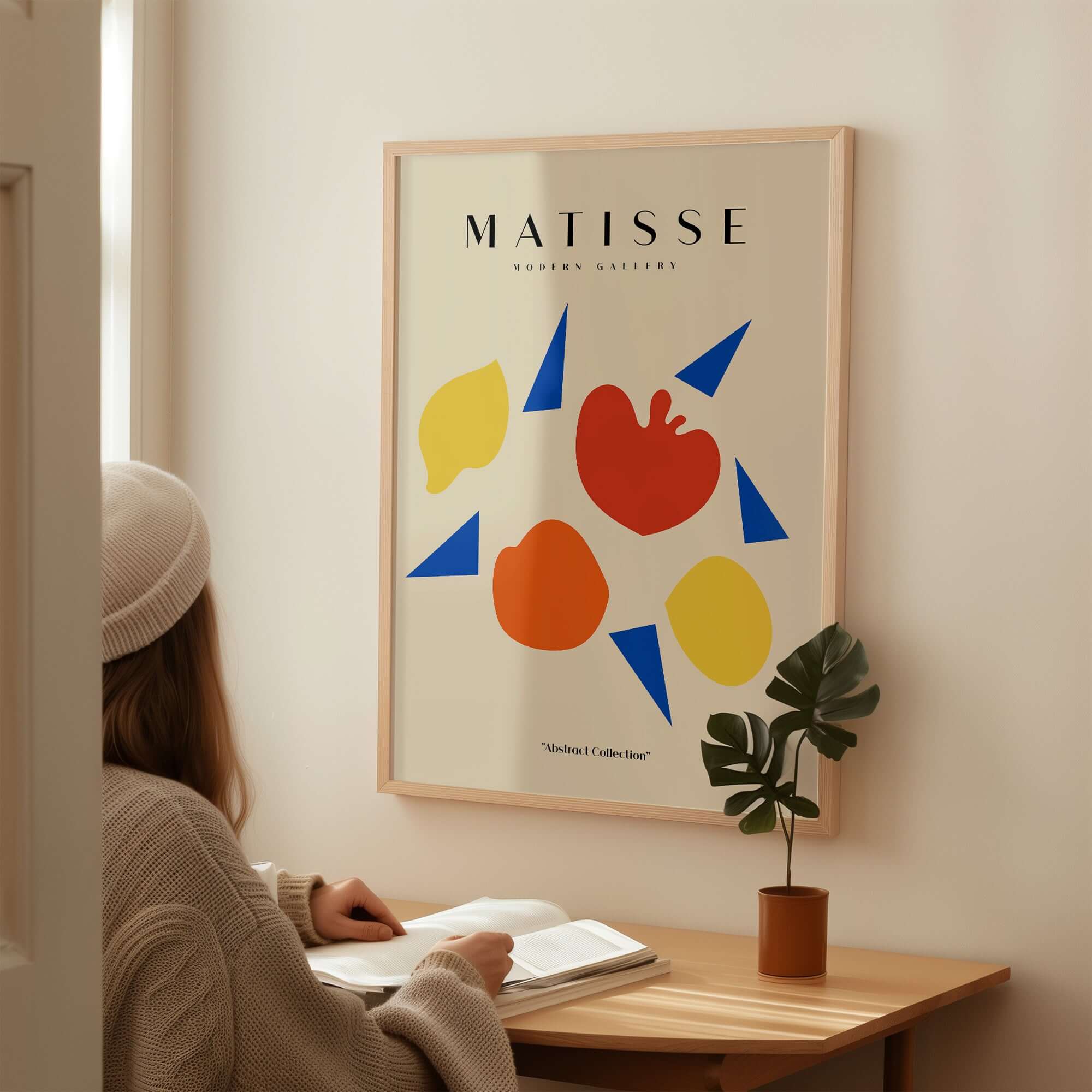 Matisse Art Prints - Abstract Fruit Shapes Blue Triangles Poster displayed on wall with person reading nearby.