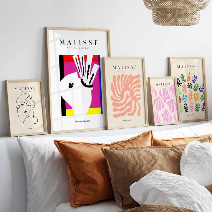Matisse art prints on a shelf showcasing abstract designs and colors in framed wall art.