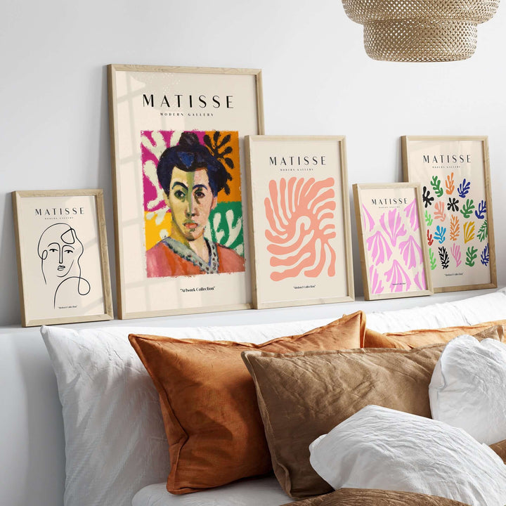 Styled interior featuring framed Matisse art prints, showcasing abstract portraits and colorful leaf designs on a shelf.