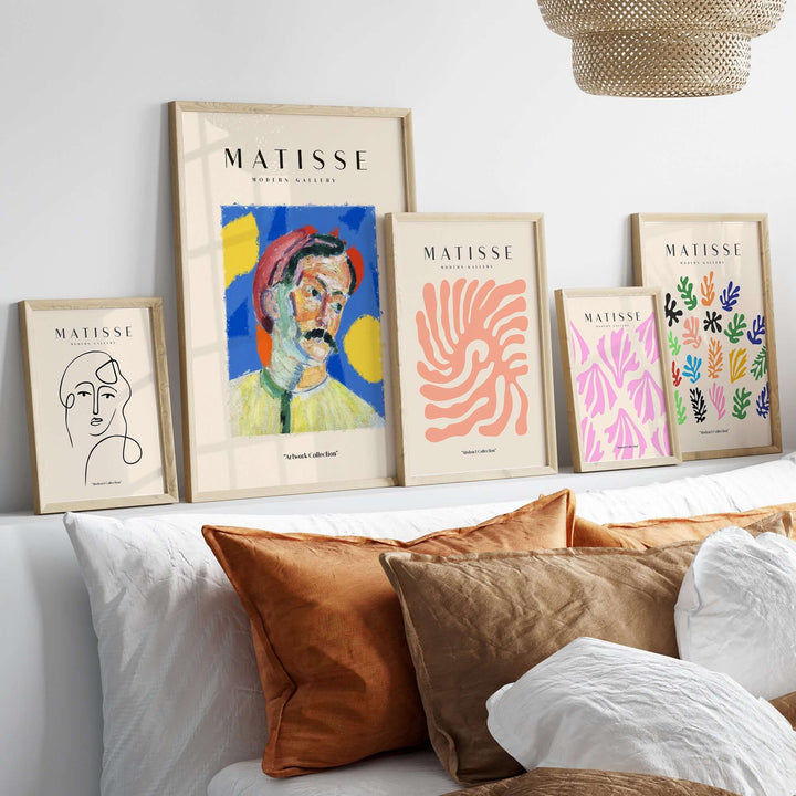 Framed Matisse art prints on a shelf, showcasing colorful abstract designs and portraits in a modern decor setting.