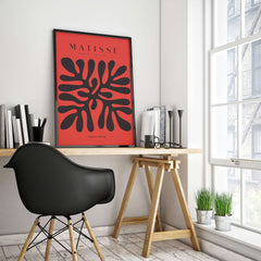 Matisse Art Prints -  Black Abstract Coral Shape Red Poster displayed in a modern workspace with a stylish black chair.