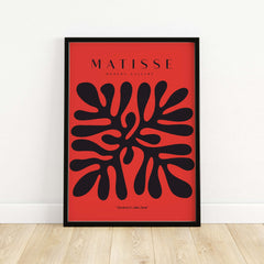 Matisse Art Prints -  Black Abstract Coral Shape Red Poster displayed on a wall, showcasing bold black shapes on red background.