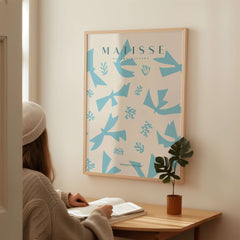 Matisse Art Prints -Blue Abstract Birds Botanical Pattern Poster displayed in a room with a person reading at a table.
