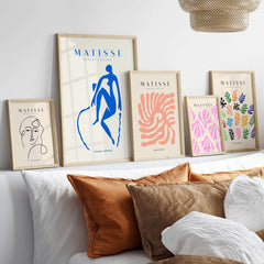 Matisse Art Prints -  Blue Nude Seated Figure Poster displayed on a shelf with other art prints in stylish frames.