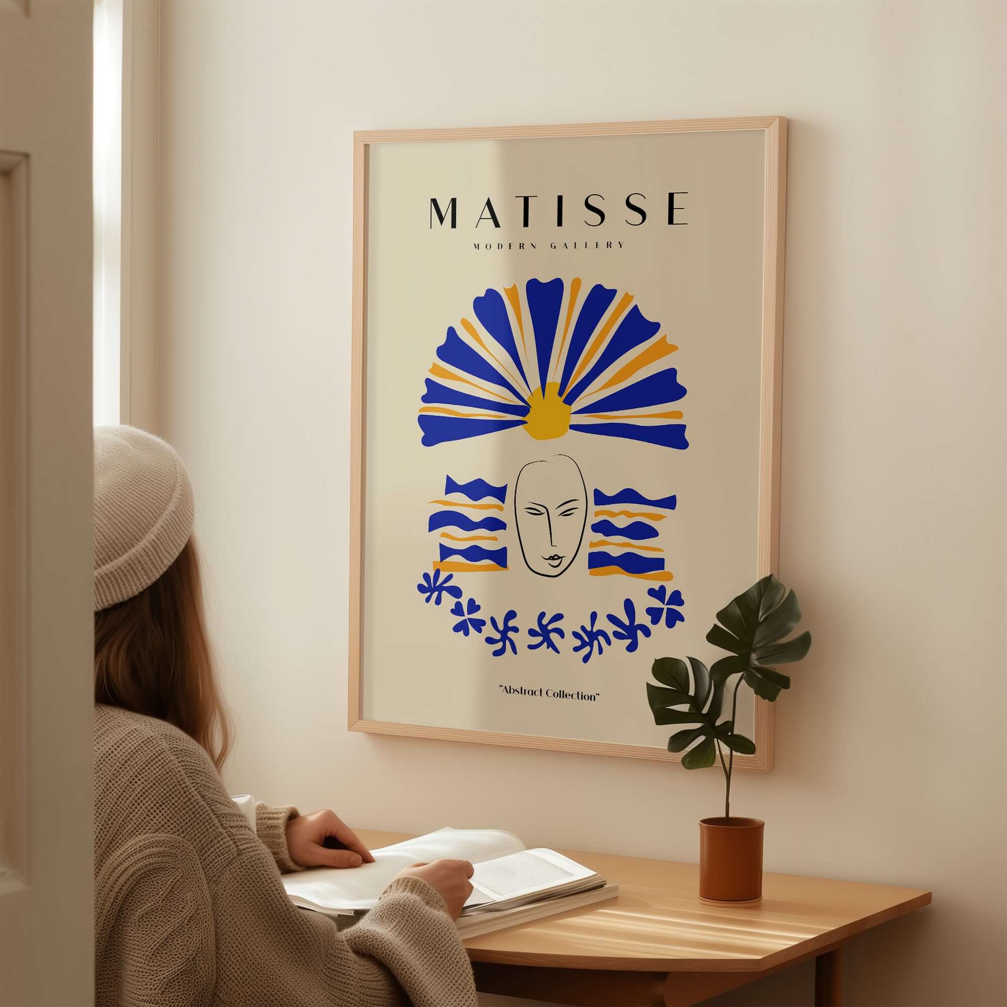 Matisse Art Prints - Blue & Yellow Abstract Face displayed on a wall with a person admiring it, featuring a minimalist design.