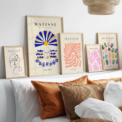 Matisse Art Prints - Blue & Yellow Abstract Face displayed among other Matisse prints on a stylish shelf.
