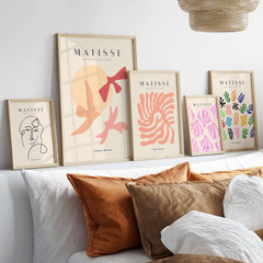 Matisse Art Prints - Abstract Birds Sun Shapes Poster displayed on a modern shelf with decorative pillows.