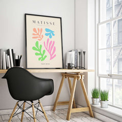 Matisse Art Prints - Colorful Abstract Cut Outs Wall Art displayed on a desk, featuring vibrant shapes against a beige background.