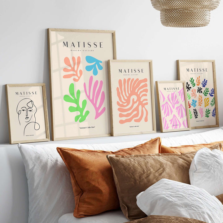 Matisse art prints featuring colorful abstract cut-outs displayed on a wall above cozy throw pillows.