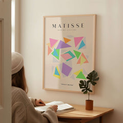 Matisse Art Prints - Colorful Geometric Triangles Poster displayed in a modern interior with a person reading.