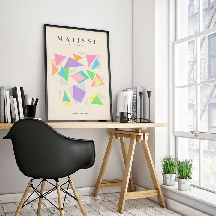 Matisse art print featuring colorful geometric triangles on a wall in a modern workspace.